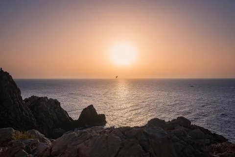 Sunset over the coast, rock formations, big ball sunshine Stock Photos