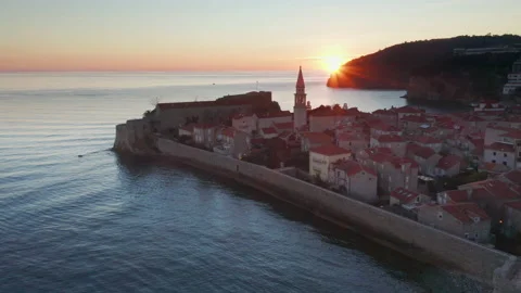Sunset over coastal old town Budva Montenegro. Silhouette of church bell tower Stock Footage 233430481