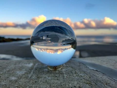 Sunset over a Cornish beach seen through a lens ball Stock Photos