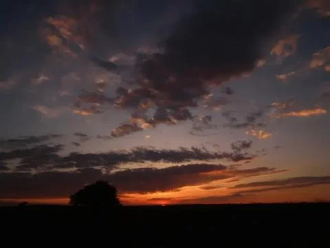 Sunset over dark clouds with orange and purple sky Stock Photos
