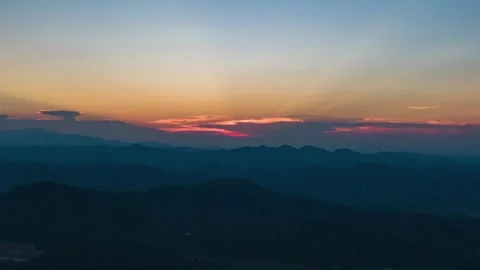 Sunset over dark mountain silhouettes with glowing orange and purple evening sky Vídeos de archivo 347038632