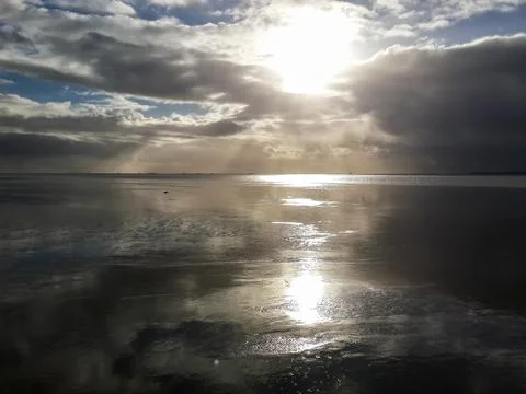 Sunset over dark mud flats at North Sea, Dagebuell, Germany Stock Photos