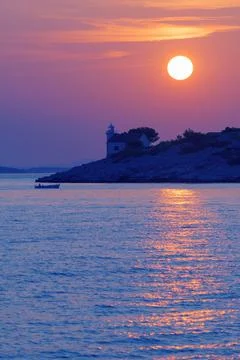 Sunset over desolate lighthouse on Murter island in Adriatic sea Stock Photos