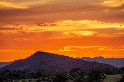 A sunset over a distant mountain 库存照片