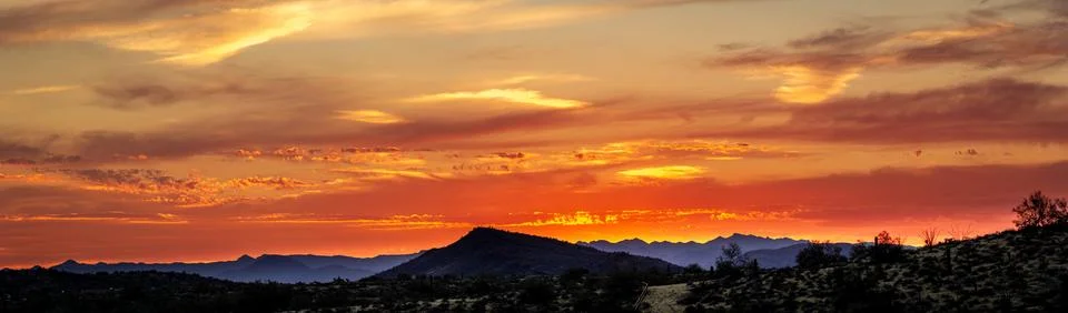 A sunset over a distant mountain 스톡 사진