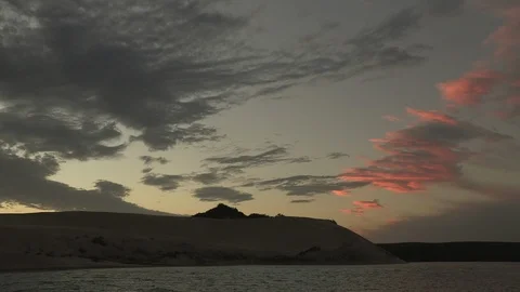 Sunset over dunes and water timelapse Stock Footage