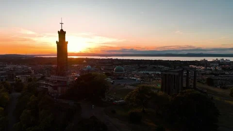 Sunset over edinburgh with monument and urban landscape in view Stock Footage 313999370
