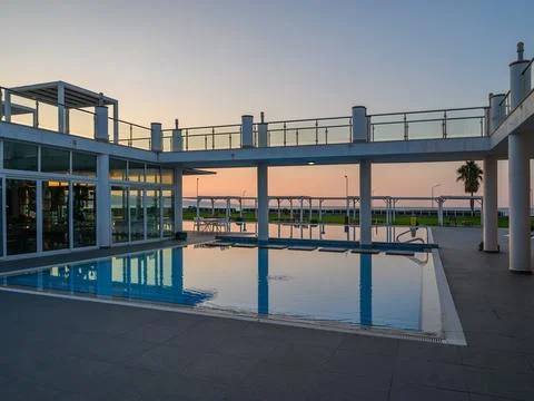 Sunset over an elegant poolside area reflecting vibrant hues in a tranquil .. Foto stock