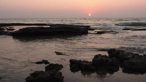 Sunset over an empty rocky beach on a warm evening Stock Footage 153046071