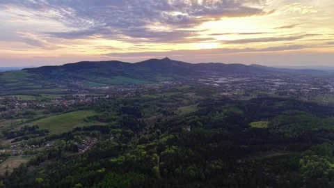 Sunset over expansive valley with rolling hills, distant town, patchwork fields, Stock Footage 342358652