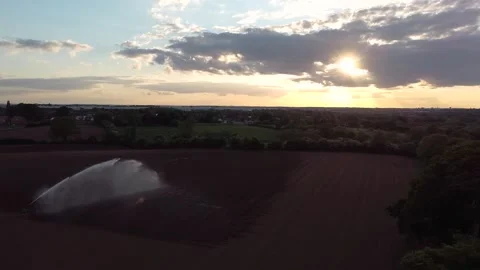 Sunset over a farm with a water sprinkler Stock Footage