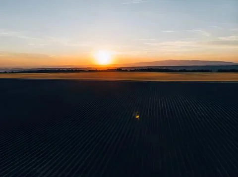 Sunset over farmland with fields and sky view Stock Photos