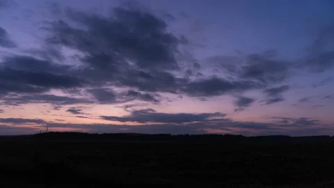 Sunset over field with clouds moving towards camera Stock Footage 134812532
