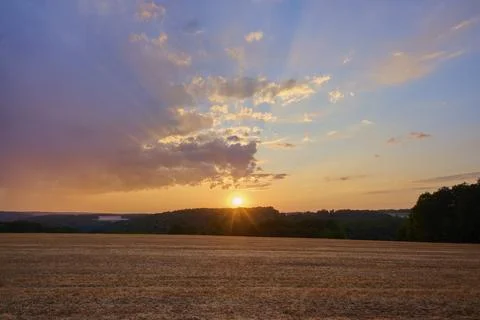 Sunset over a field, with dramatic sky and warm colors, summer, Reichartshausen, Stock Photos