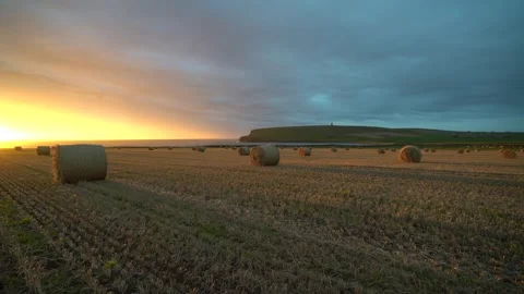 Sunset over a field of straw bails looking over to kitchener's memorial, orkney Video stock 301240302