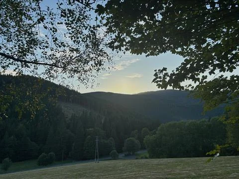 Sunset over forested mountain hills. Stock Photos