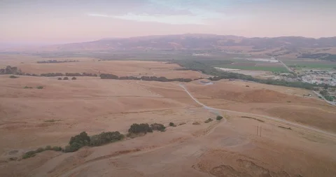 Sunset over golden hills, fields, and distant mountains. San Juan Bautista, USA Stock Footage 93108436
