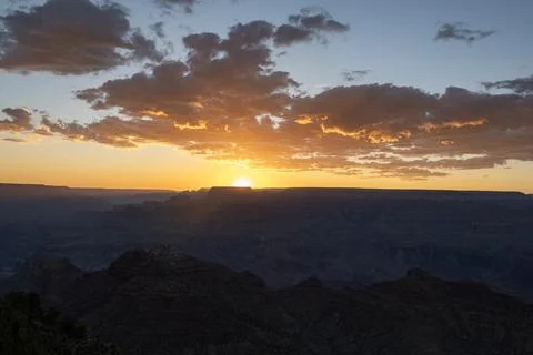 Sunset over Grand Canyon with dramatic clouds and mountain silhouettes in e.. Stock Photos