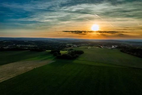 Sunset over green fields and village terrain. View from. Stock Photos