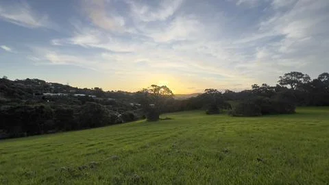 Sunset over a green hill Stock Photos