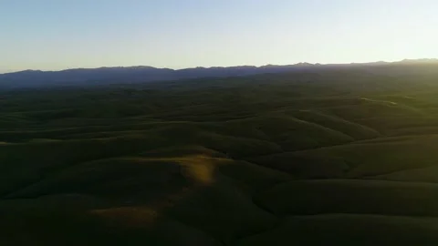 Sunset over green hilly terrain in Kettleman city in california Stock Footage 155458013