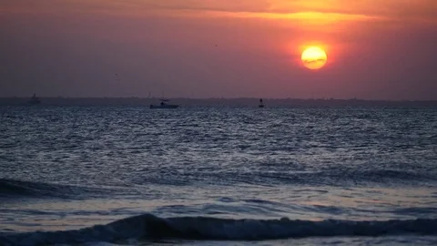 Sunset over harbor with boat floating and waves Stock Footage 77839115