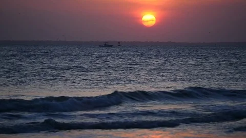 Sunset over harbor with boat floating and waves Stock Footage 77839209