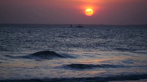 Sunset over harbor with boat floating and waves Stock Footage 77839967