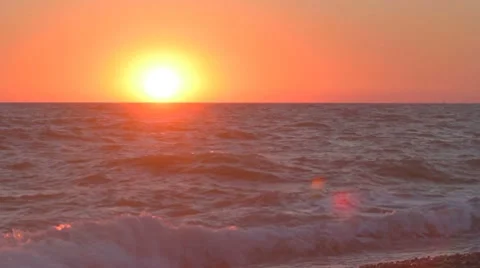 Sunset over the horizon with waves splashing on the beach Stock-Footage 8365959