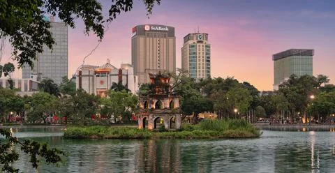 Sunset over the iconic Turtle Tower in Hoan Kiem Lake, Hanoi, Vietnam with city Stock Photos
