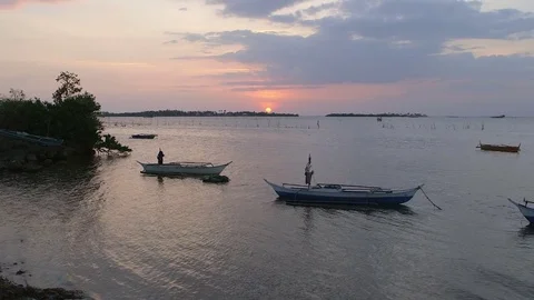 Sunset over the Indian ocean, docked fishing boats in foreground Stock Footage 76803697