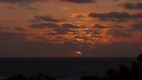 Sunset over Indian Ocean, sun obscured by  clouds. Time lapse Video stock 165983277