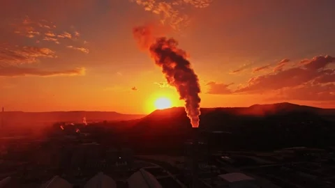 Sunset over industrial area with smoke rising from factory Stock Footage 339650886