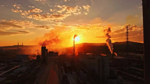 Sunset over industrial area with smoke and factories during late afternoon Stock Footage 340879769