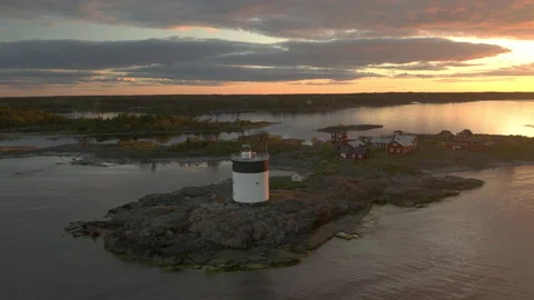 Sunset over an island with a lighthouse Stock Footage 133375705