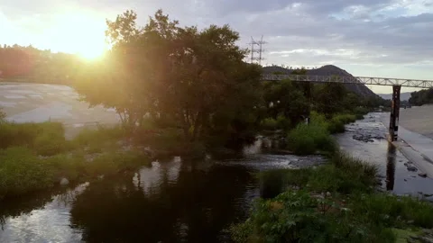 Sunset over LA River in Silverlake - Drone going up river under walking bridge 库存影片 202237436
