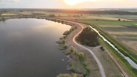 Sunset over lagoon with footpath along lagoon (drone flight shot) Stock Footage 276351431