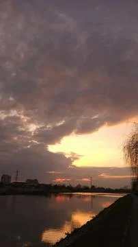 Sunset over lake with clouds and trees Stock Photos