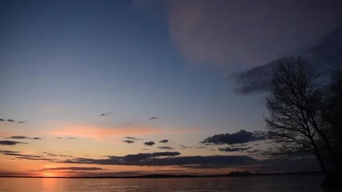 Sunset over the lake, clouds floating in the sky, time lapse Stock Footage 239562137