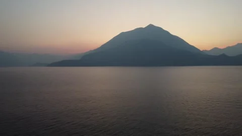 Sunset over Lake Como with Vibrant Orange Sky Stockbeeldmateriaal 313563103