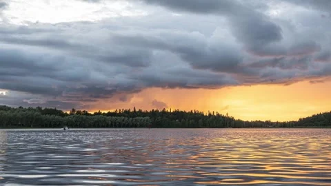 Sunset over a lake with dark clouds in time lapse. Stock Footage 246543110