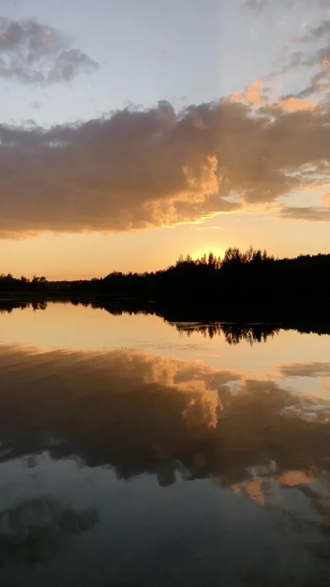 Sunset over lake, forest silhouette on horizon Stock Footage 158176493