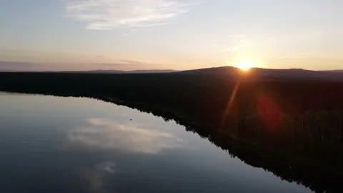 Sunset over the lake in the forest view from the drone Stock Footage
