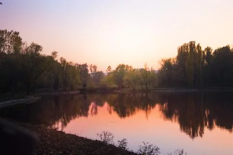 Sunset over the lake in the park in the fall. Stock Photos