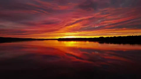 Sunset over lake, reflections, tinted clouds, movement, Germany, 4K Drone Stock Footage 279756470