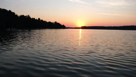 Sunset over lake with rowing boat on water. Golden hour landscape with Stock Footage 340356838