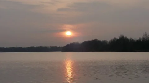 Sunset over the lake, sun reflection in time-lapse,Sunset at time-lapse Video stock 77405796