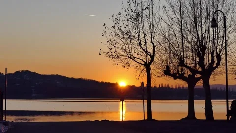 Sunset over lake  trees in foreground 스톡 동영상 279785757