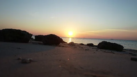 Sunset over the lapping beach and water Vídeo Stock 89903507