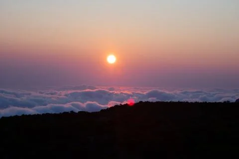Sunset over marshmallow clouds with lens flare Stock Photos